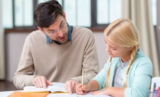 Private tutor helping girl with homework