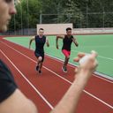 Man timetracking two runners with a stopwatch