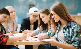 Group of students at high school doing homework in class