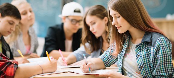 Group of students at high school doing homework in class