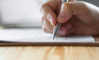 Hand and pencil writing on an exam